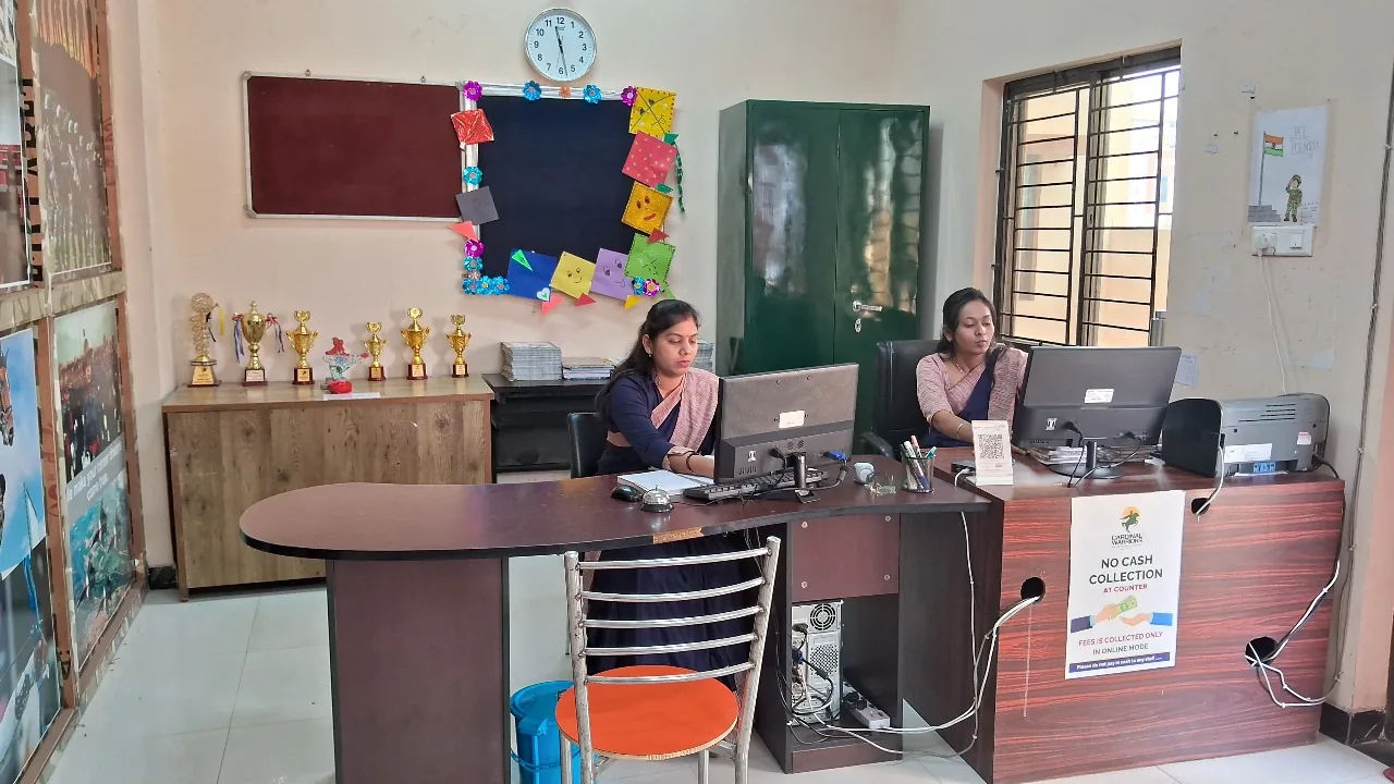 School office at Cardinal Warriors with staff working at computers and trophies on display