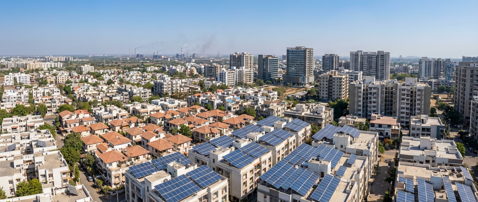 Aerial view of rooftop solar panel installations across Gujarat cityscape showing residential and commercial buildings