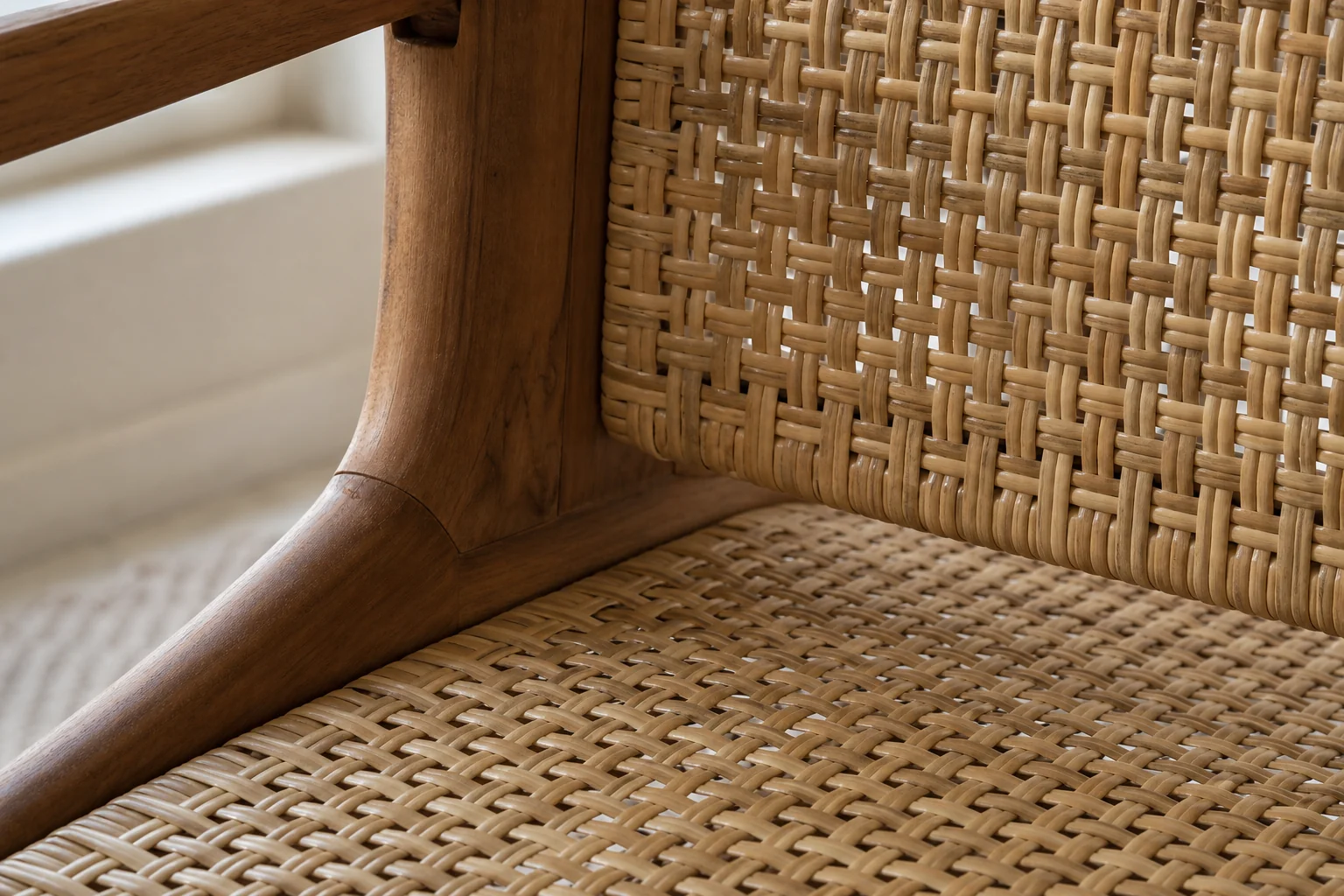 Rattan & Cane Furniture Shopping Guide for Gurugram Homes 2 Close-up detail shot showing rattan weave texture and a solid wood frame joint. Photorealistic close-up photograph of a handcrafted rattan chair showing the tight woven cane pattern meeting a solid teak wood frame joint, natural daylight