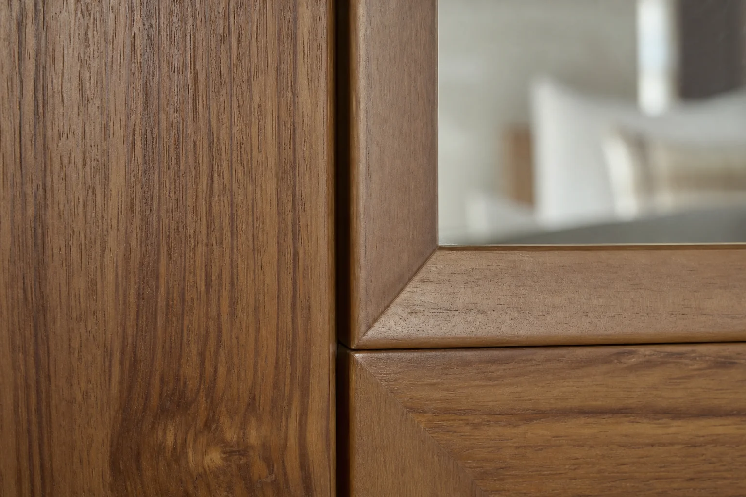 Teak Wardrobe with Mirror: What Drives the Price? 2 Close-up of a framed mirror door on a teak wardrobe showing wood grain and mirror edge. photorealistic close-up photo of a teak wood wardrobe door corner where a framed mirror meets the solid wood frame, visible natural teak grain in warm