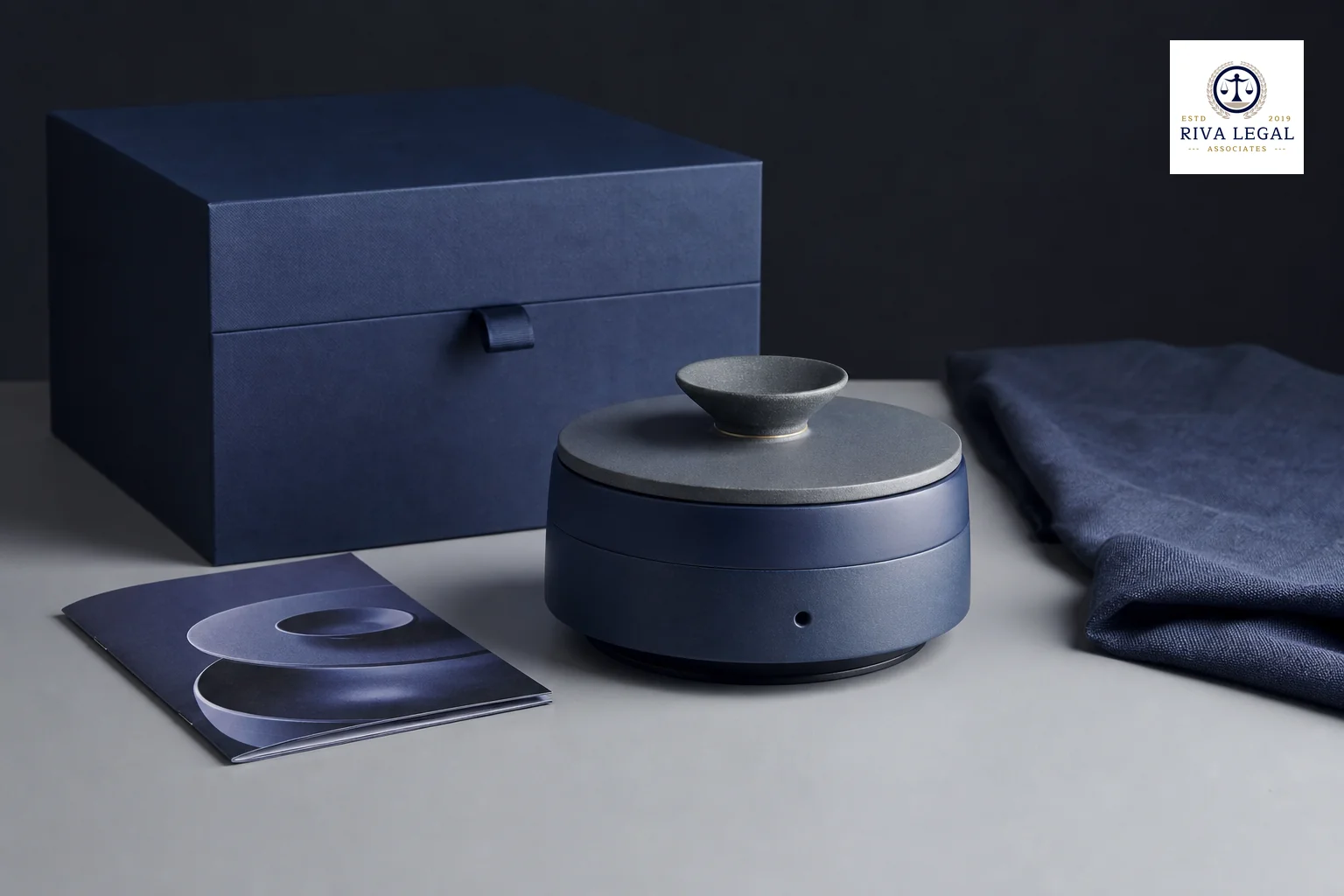 Photorealistic image showing a physical product with packaging and design elements representing layered IP protection. photorealistic: A photograph of a well-designed consumer product, such as a minimalist ceramic or metal device, sitting