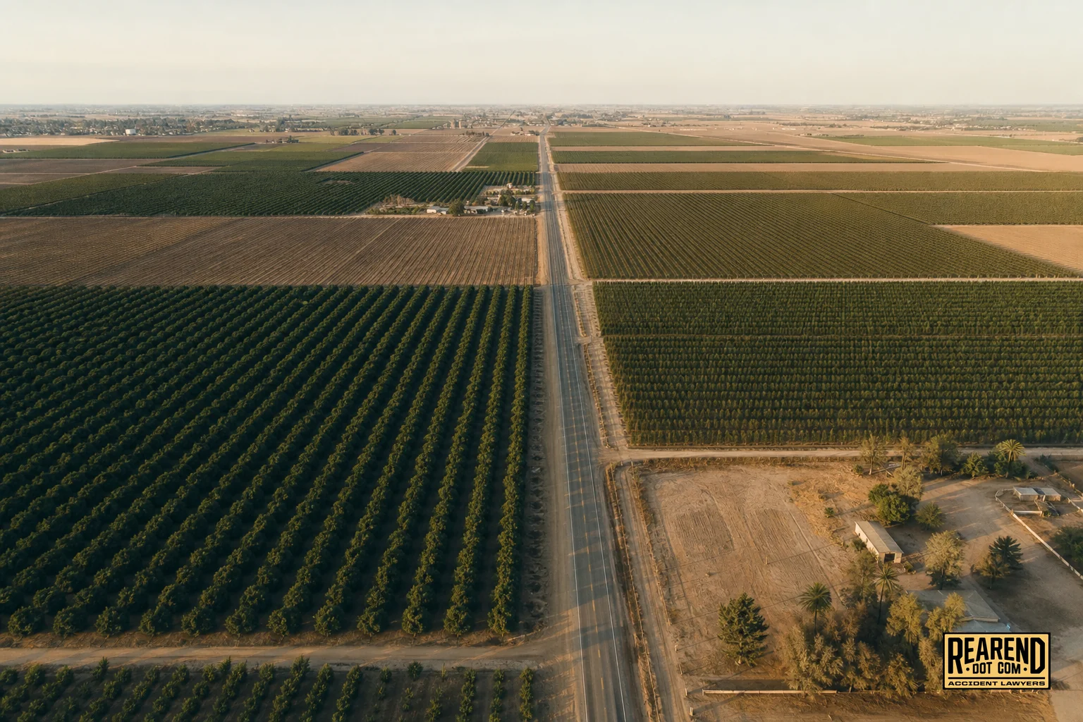 Aerial-style view of Fresno County farmland roads with irrigation fields, showing the rural highway context. photorealistic aerial drone-style photograph of Fresno County, California farmland crossed by a straight rural two-lane road