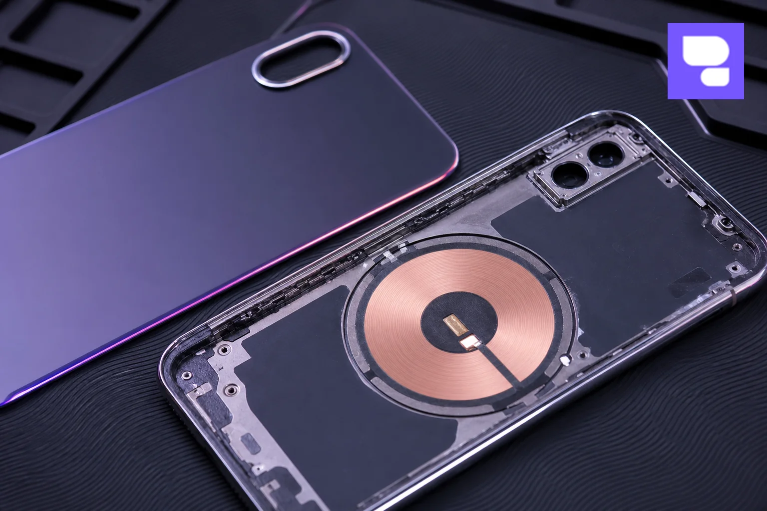 Macro shot of iPhone back glass and internal components showing precision engineering. Photorealistic macro photograph of a disassembled iPhone back glass panel and internal frame resting on an anti-static mat, showing the wireless charging