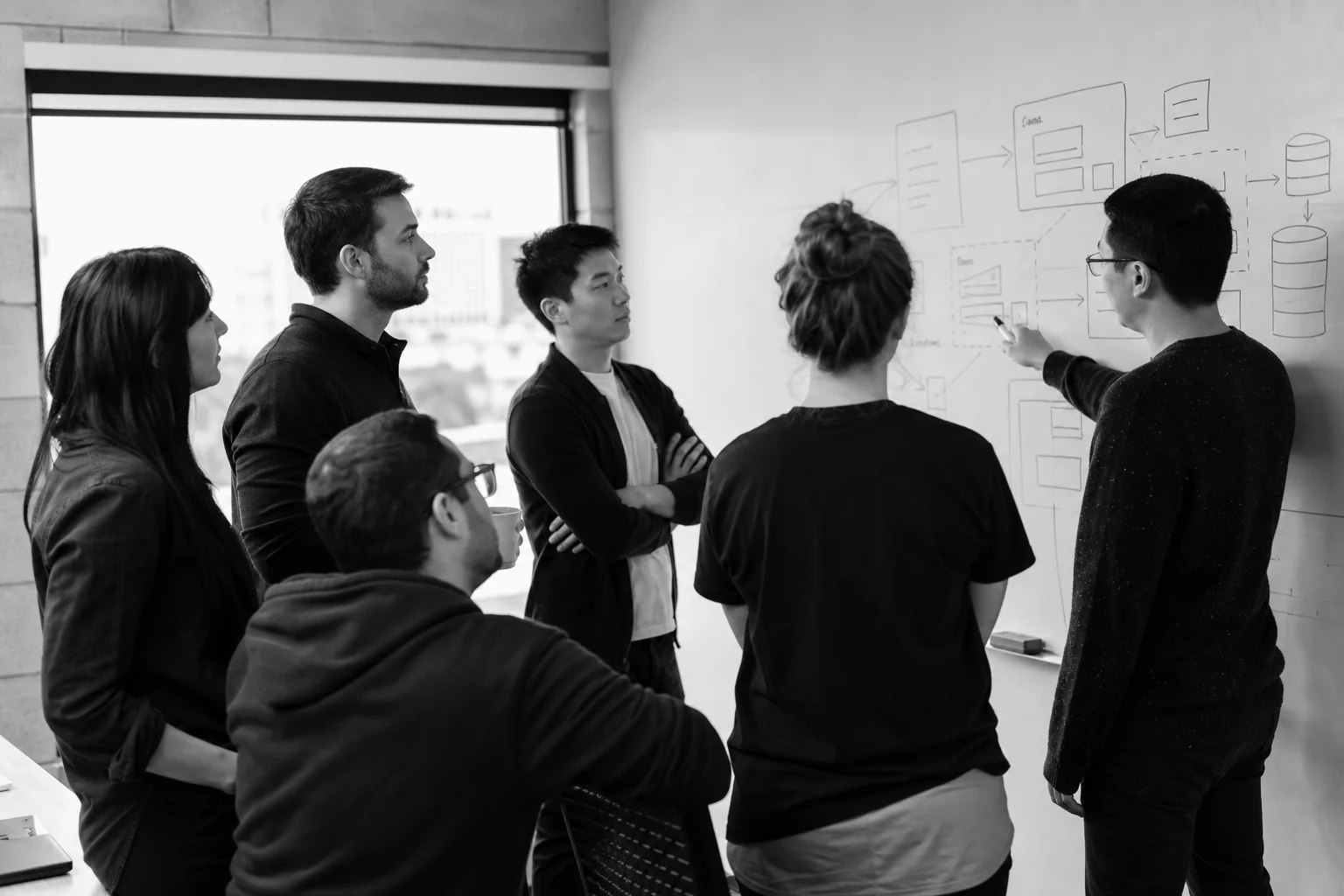 A small SaaS engineering team in a planning meeting discussing architecture on a whiteboard. photorealistic: A small team of six software engineers gathered around a whiteboard covered with abstract architecture diagrams and boxes