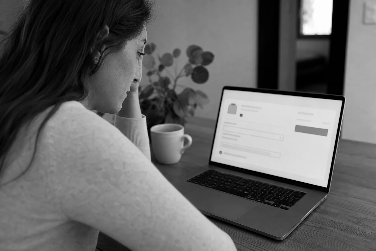 Photo of a frustrated online shopper on a laptop at a checkout screen with a shipping error, representing lost conversions. photorealistic: person sitting at a home desk looking at a laptop screen with a concerned expression, laptop