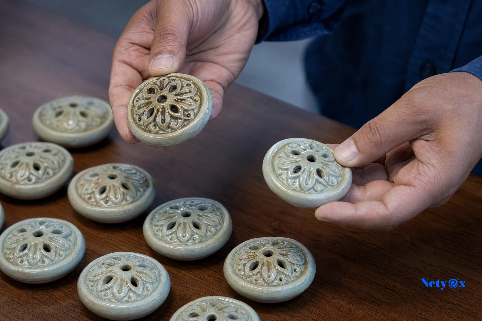 Close-up comparison of an approved handicraft sample next to bulk production units. photorealistic photo, close-up shot of hands comparing an approved handcrafted decor sample piece against several bulk-produced identical items laid on a