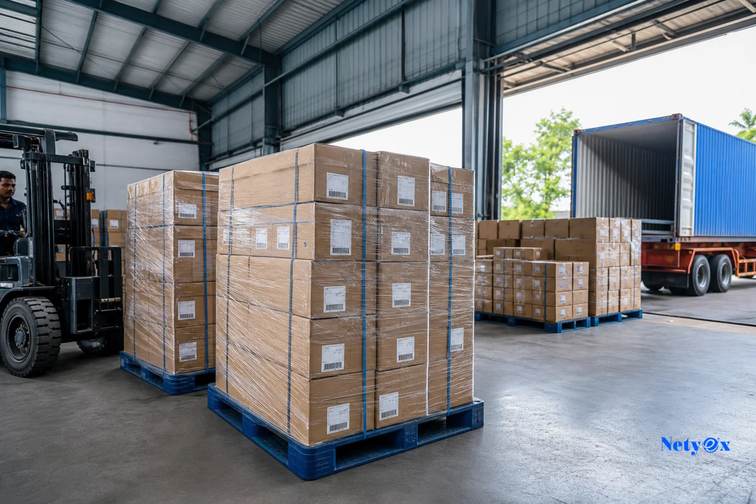 Export-ready footwear cartons being palletized and loaded for international shipment from an Indian warehouse. Photorealistic photo of stacked export cartons of footwear being wrapped and palletized in a bright Indian warehouse loading