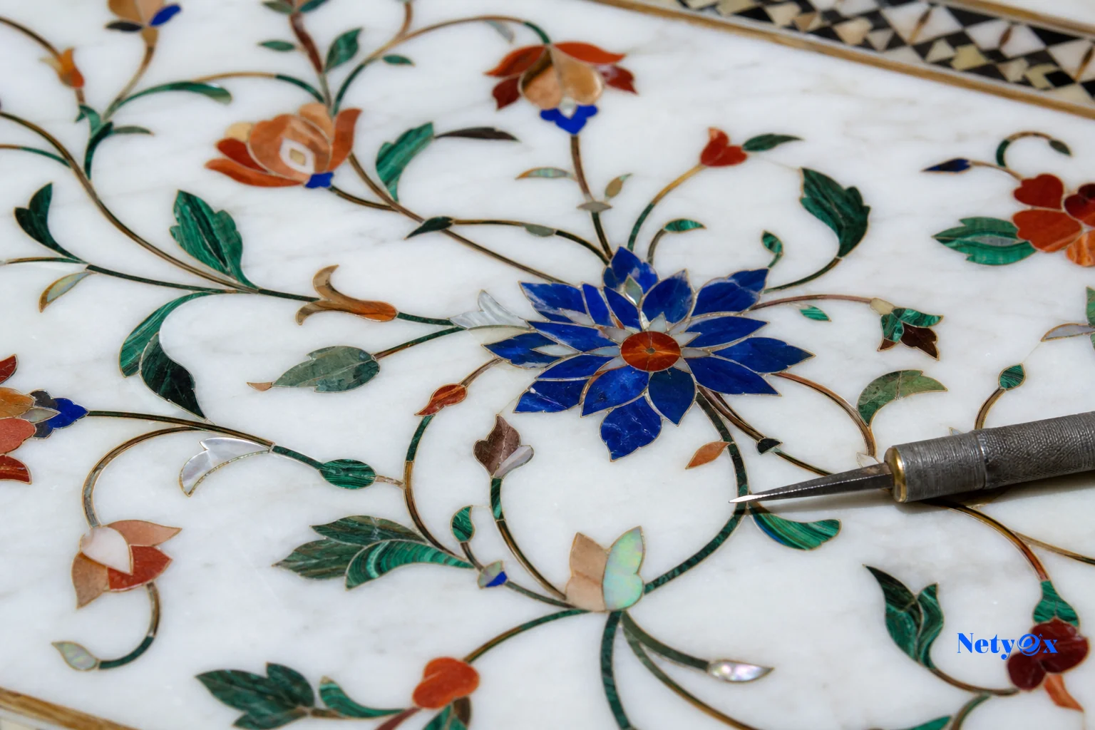 Detailed macro shot of pietra dura marble inlay work with colored stone patterns. photorealistic: macro photograph of intricate pietra dura marble inlay work on a white marble tabletop, colorful semi-precious stone floral pattern inlaid