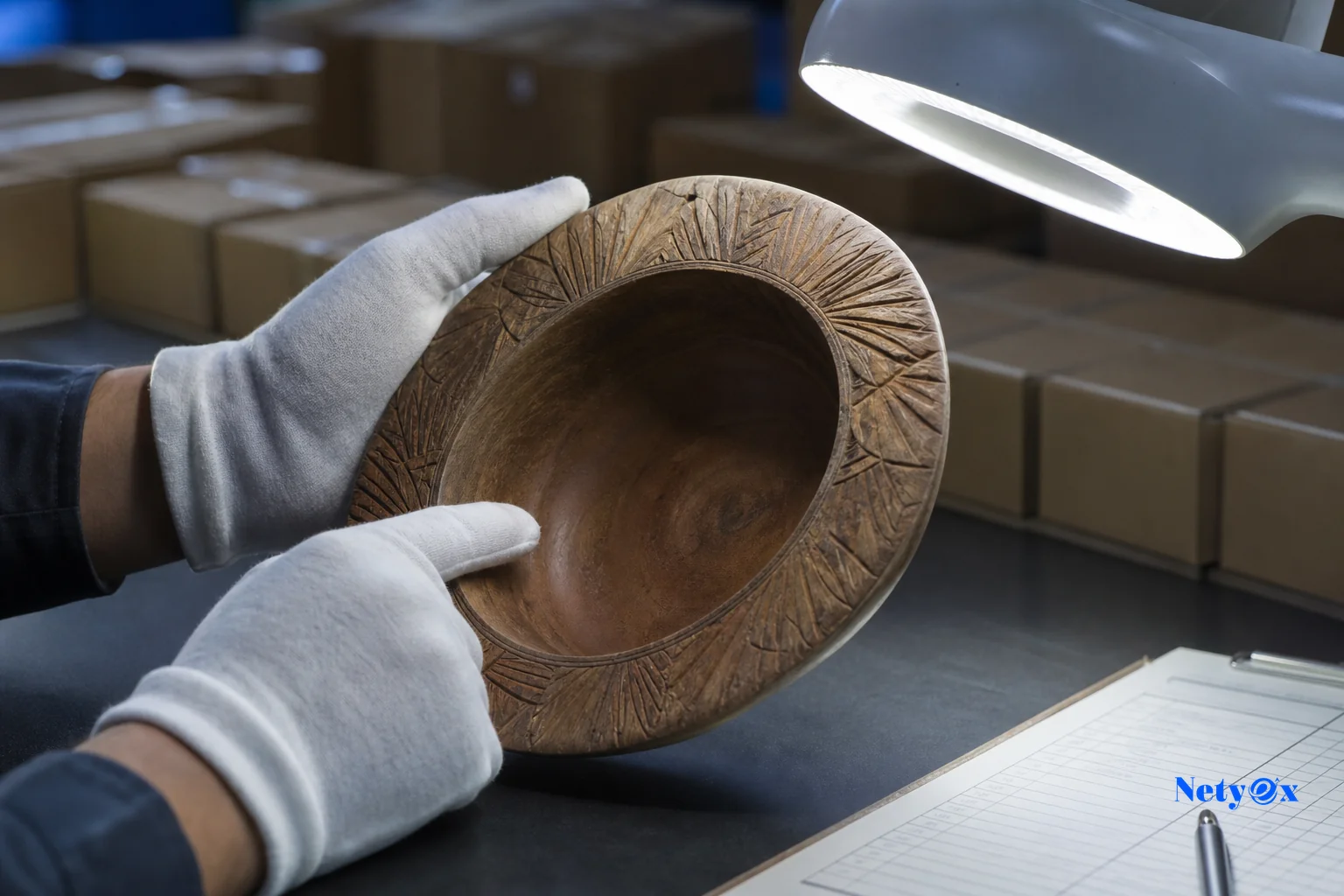 Photorealistic image showing quality inspection of home decor products before export, emphasizing pre-shipment checks. photorealistic, a close-up documentary photograph of hands wearing white cotton gloves carefully inspecting a hand-carved